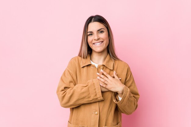 Jonge vrouw heeft een vriendelijke uitdrukking, palm op borst drukken