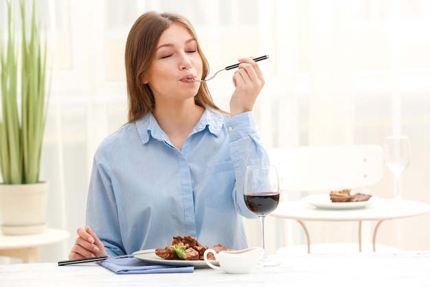 Jonge vrouw heerlijke ribben eten in restaurant