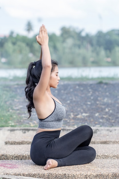 Jonge vrouw het beoefenen van yoga in park