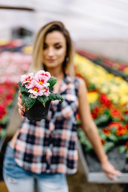 Jonge vrouw het kopen bloemen op een tuincentrum