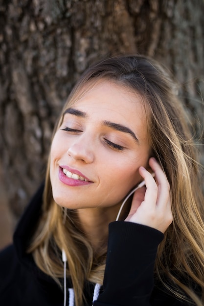 Jonge vrouw het luisteren muziek openlucht