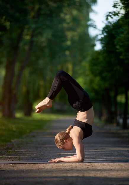 Jonge vrouw het praktizeren yoga in het park