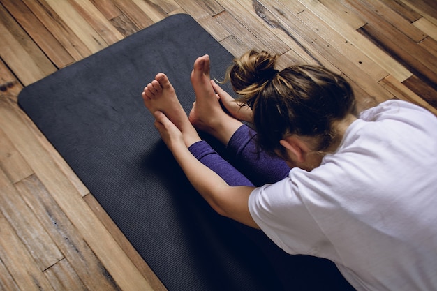 Jonge vrouw het praktizeren yoga in huis.