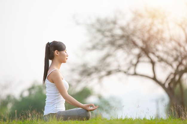 Jonge vrouw het praktizeren yoga in park openlucht. Meditatie.