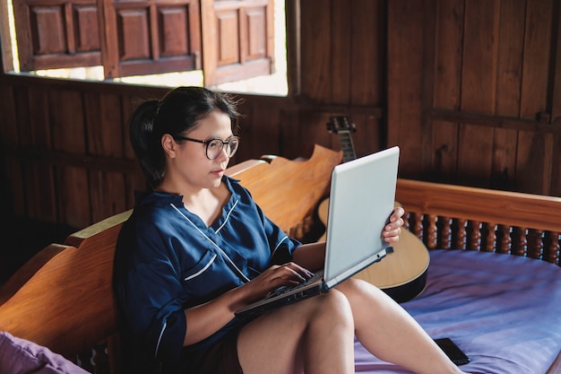 Jonge vrouw het werken zitting op laag met laptop thuis