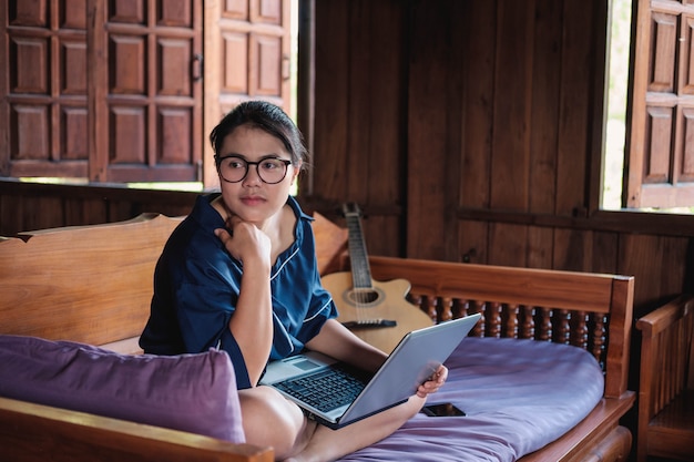 Jonge vrouw het werken zitting op laag met laptop thuis