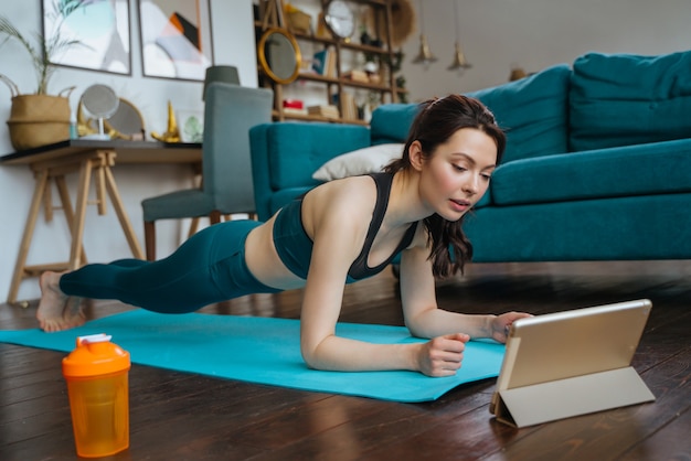 Jonge vrouw houdt zich thuis bezig met fitness