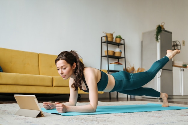 Jonge vrouw houdt zich thuis bezig met fitness