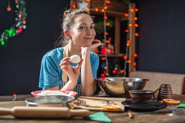 Jonge vrouw huisvrouw maakt deeg voor het koken van feestelijke gemberkoekjes