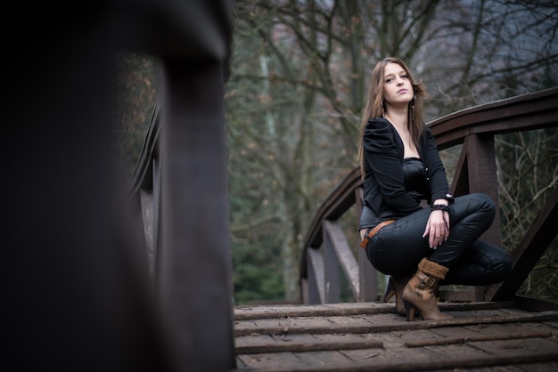 jonge vrouw hurkt bij de brug