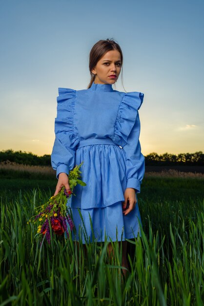 Jonge vrouw in blauw en wit gestreepte jurk