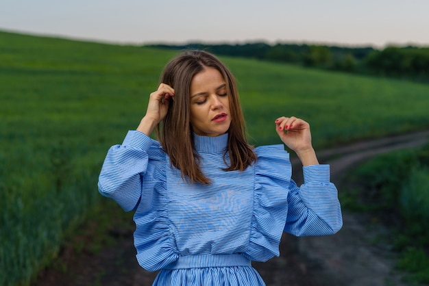 Jonge vrouw in blauw en wit gestreepte jurk