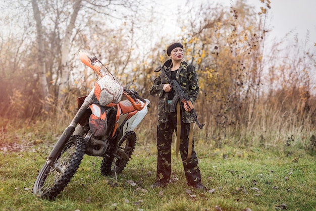 Jonge vrouw in camouflagekleding met kanon