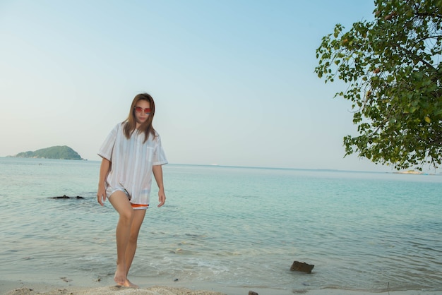 Jonge vrouw in casual kleding en staan op het strand