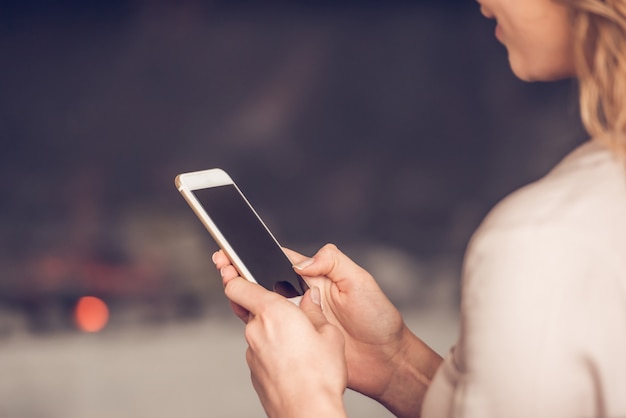 Foto jonge vrouw in casual kleding met behulp van een mobiele telefoon.