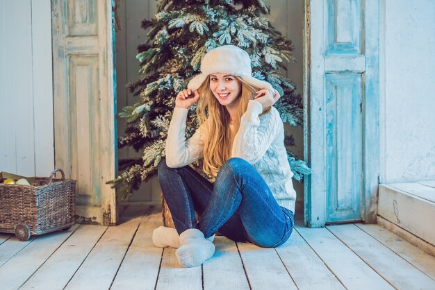 jonge vrouw in de buurt van kerstboom