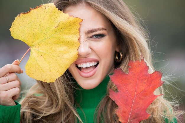 Jonge vrouw in de herfst park warm zonnig weer herfst concept hallo herfst gelukkige vrouw met de herfst schreeuw