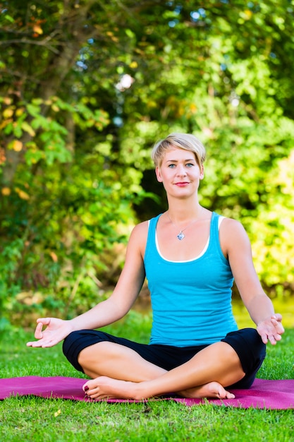 Jonge vrouw in de natuur doet yoga