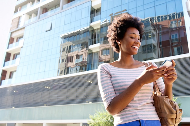 Jonge vrouw in de stad met mobiele telefoon