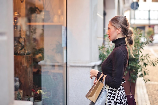 Foto jonge vrouw in de stad voor een etalage