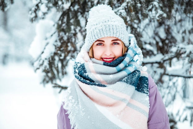 Jonge vrouw in de winter met gebreide muts en sjaal