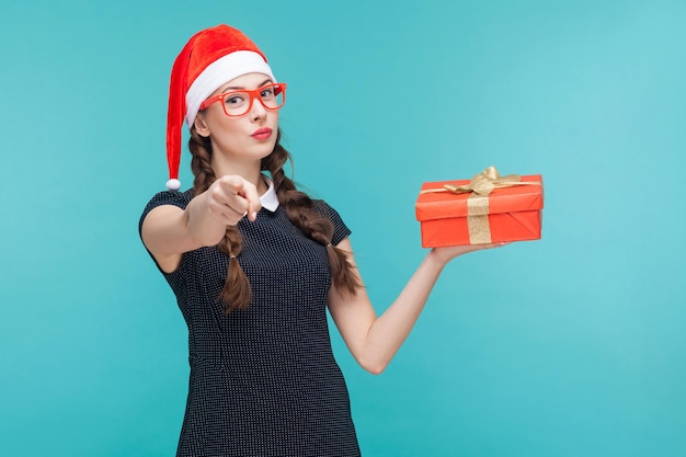 Jonge vrouw in donkere jurk en bril met geschenkdoos