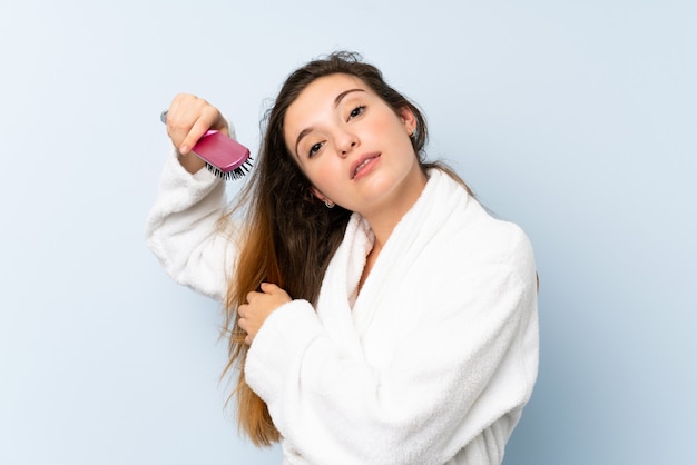 Jonge vrouw in een badjas met met haarkam