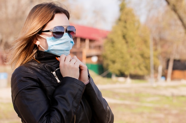 Jonge vrouw in een beschermend masker en zonnebril