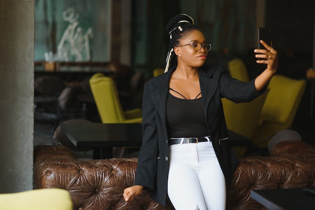 Jonge vrouw in een café met behulp van een smartphone