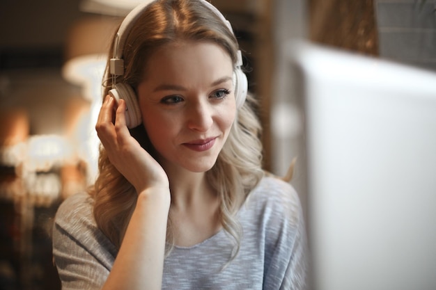 jonge vrouw in een café met een computer en koptelefoon
