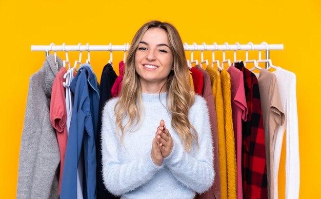 Jonge vrouw in een kledingwinkel applaudisseren