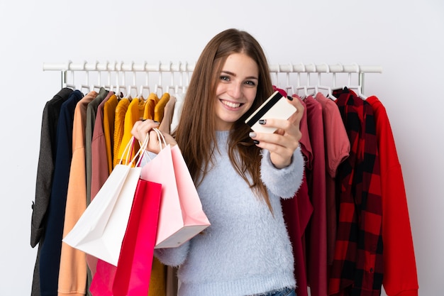 Jonge vrouw in een kledingwinkel met een creditcard