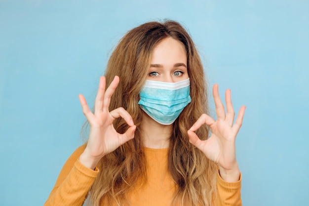 Jonge vrouw in een medisch masker dat ok toont. Coronavirus-epidemie. Covid 2019.