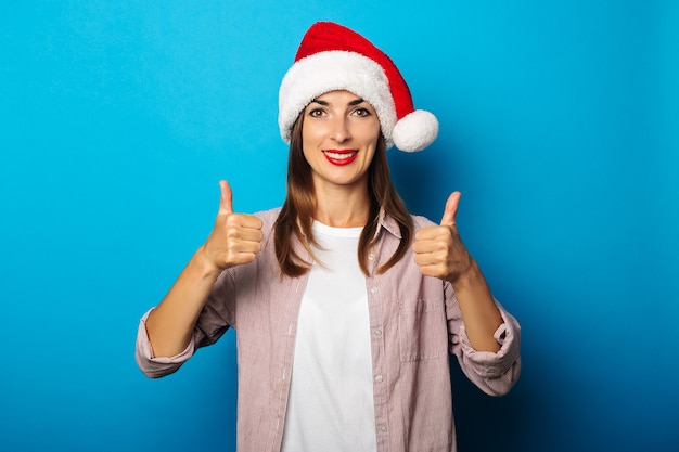 Jonge vrouw in een overhemd dat een hoed van de Kerstman draagt