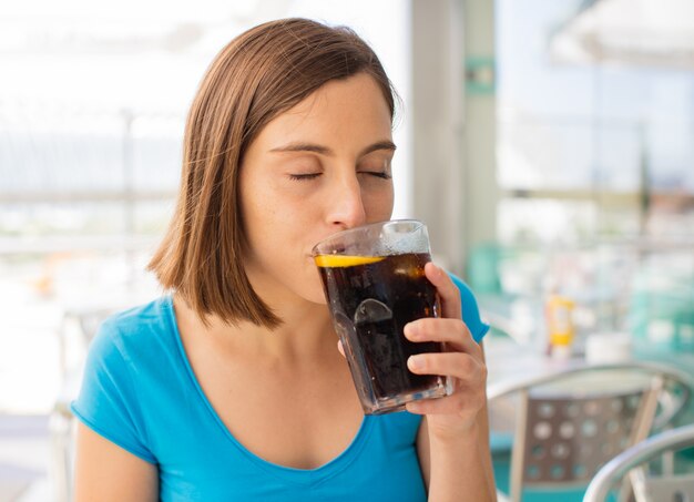 jonge vrouw in een restaurant met een cola