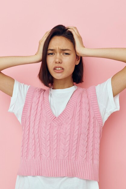 Jonge vrouw in een roze vest poseren in vrijetijdskleding Lifestyle ongewijzigd