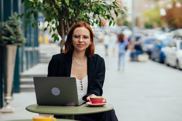 Jonge vrouw in een straatcafé kijkt in de camera