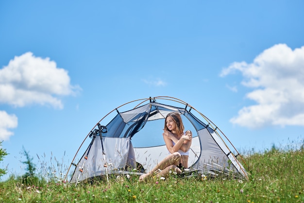 Jonge vrouw in een tent op het gras