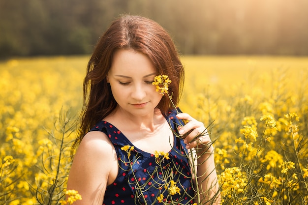 jonge vrouw in een veld van koolzaad op een zonnige dag