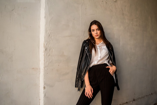 Jonge vrouw in een zwart leerjasje en een witte blouse