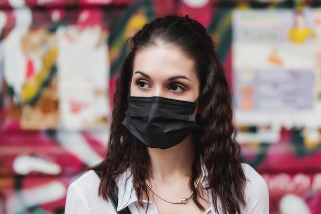 Jonge vrouw in een zwart masker. Bescherming tegen сovid-19. Hoge kwaliteit foto