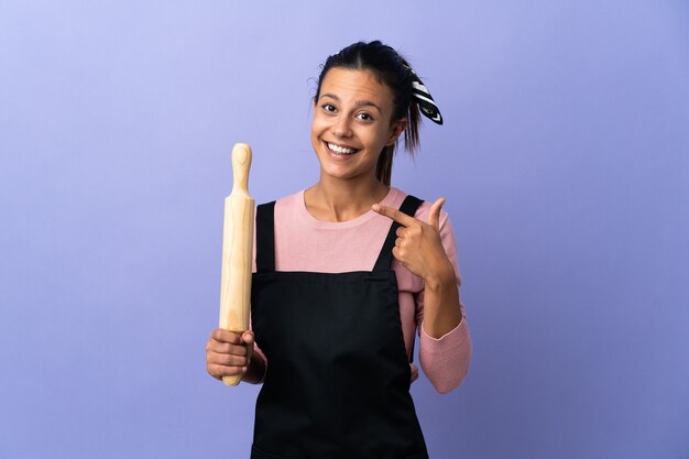 Jonge vrouw in eenvormige chef-kok met een duim omhoog gebaar