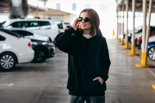 Jonge vrouw in glazen en zwarte hoodie