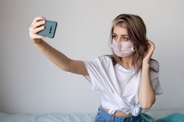 Jonge vrouw in haar bed met een beschermend masker