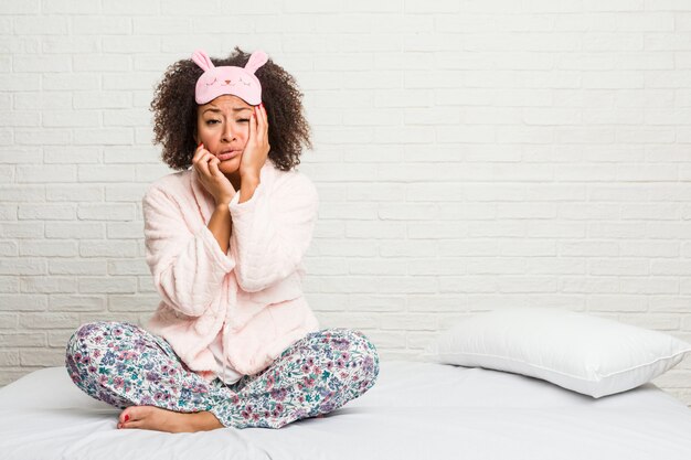 Jonge vrouw in het bed dragen pijama zeuren en huilend troosteloos.