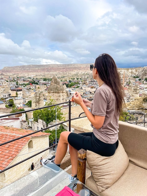 Jonge vrouw in jurk op het dak met prachtig uitzicht over Cappadocië in Turkije