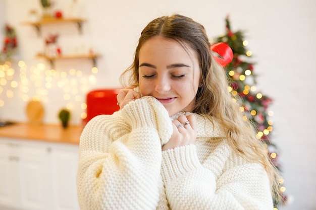 Jonge vrouw in kerst versierde keuken