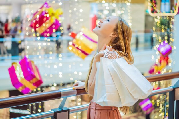 Jonge vrouw in kerstwinkelcentrum met kerstinkopen Beauty kopen kerstnachtwinkelkortingen