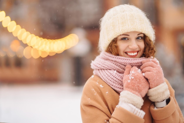 Jonge vrouw in kleding in winterstijl die zich voordeed op de feestelijke straatmarkt Koud weer Wintermode