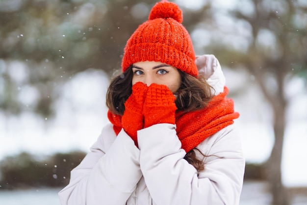 Jonge vrouw in kleding in winterstijl tegen de achtergrond van besneeuwd bos Natuurvakanties